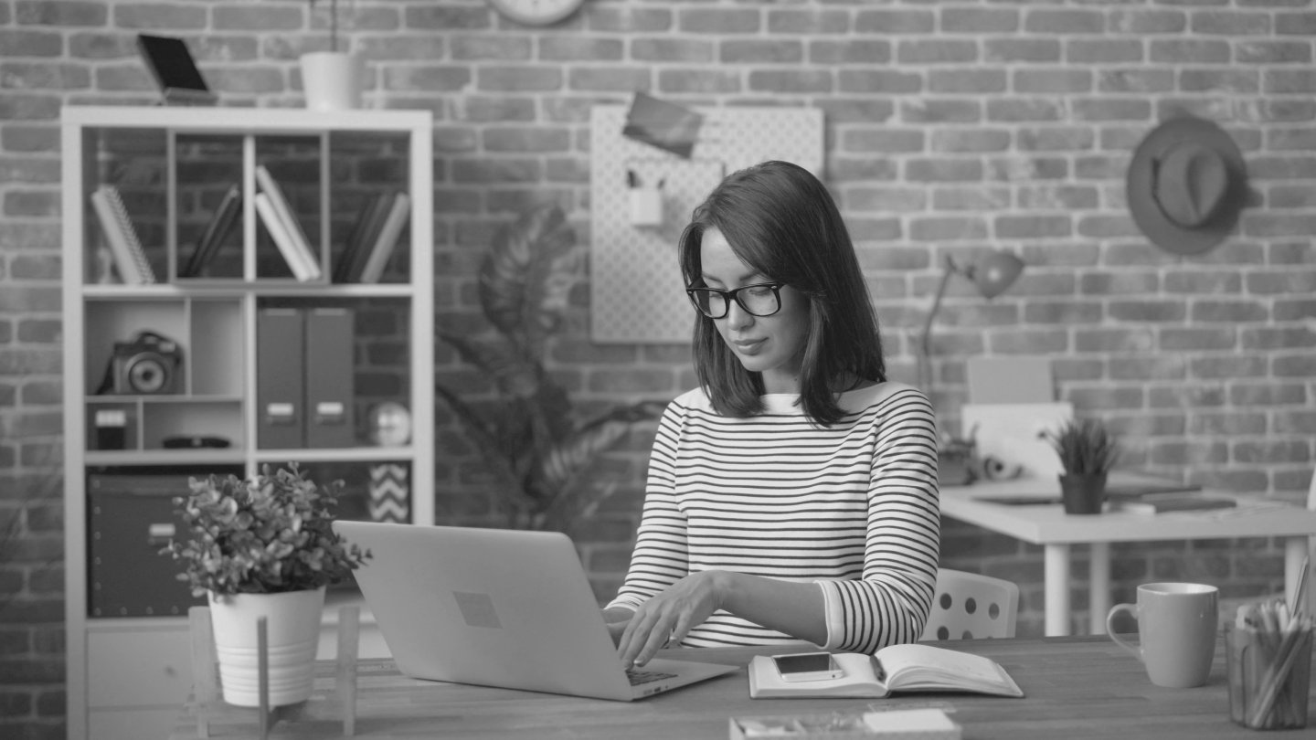 Professionnelle au bureau analysant ses finances sur un portable, reflet d’un accompagnement financier personnalisé.